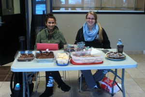 Carly Schmidt and teammate Victoria Pappas selling baked goods for the girls' basketball team. They will be in the Odeon building lobby through Thursday, Oct. 23. Photo by Kyle Morrisson