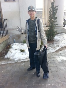 First year student, Ryan Zhang cleans up downtown. By Brittany Bennett.