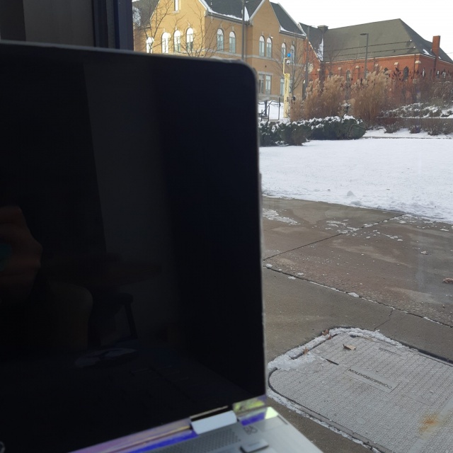 A laptop near a window facing the Post House residence building