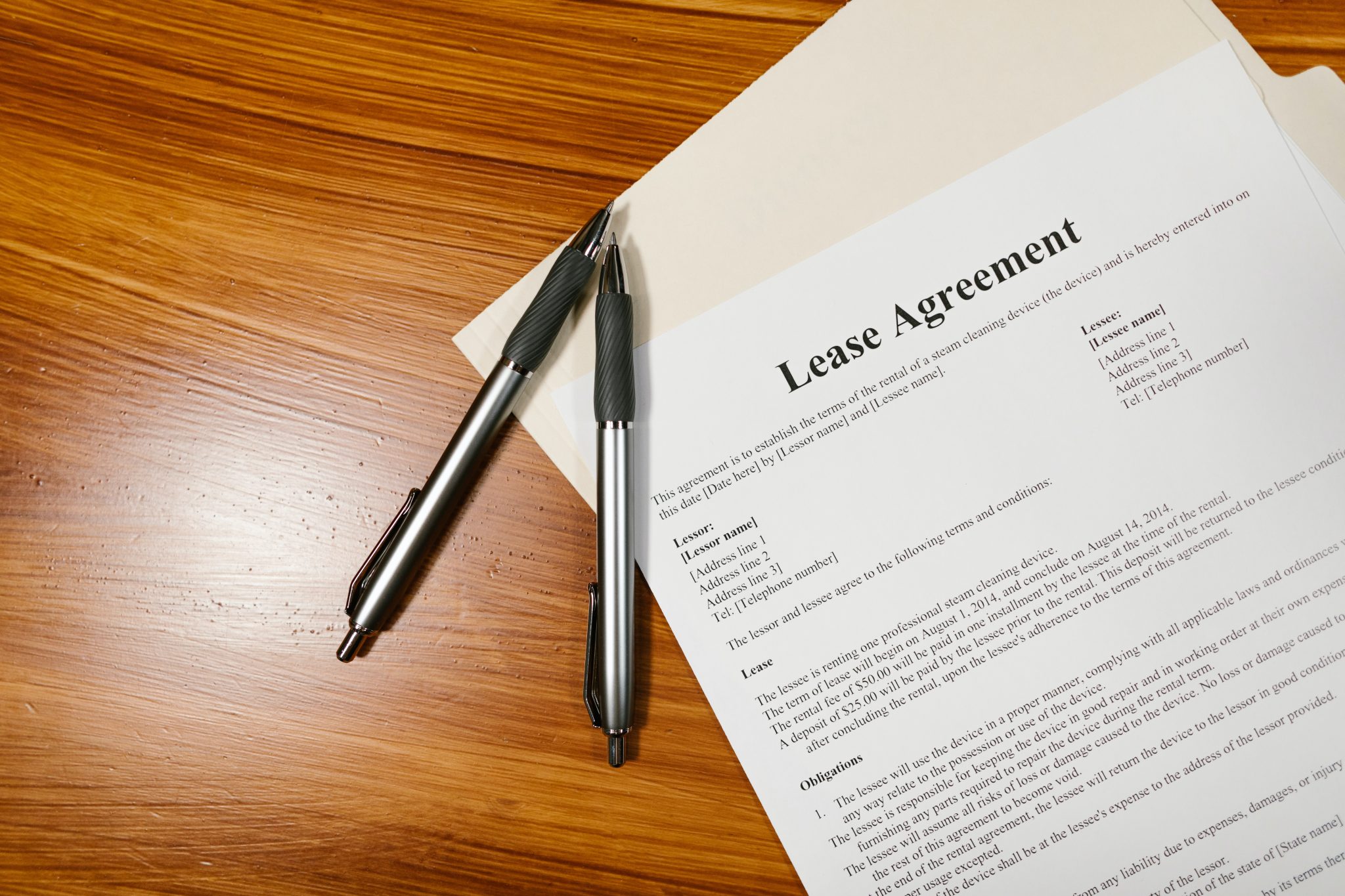 Two pens and a lease agreement on a table